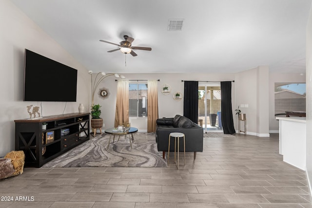 living room with ceiling fan, light hardwood / wood-style flooring, and lofted ceiling