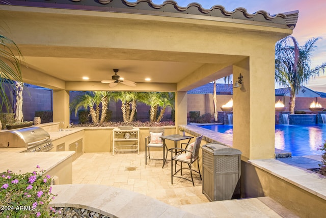 patio terrace at dusk featuring pool water feature, area for grilling, ceiling fan, grilling area, and a fenced in pool