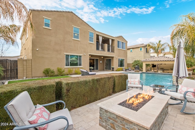 view of pool with an outdoor fire pit, a patio area, and pool water feature