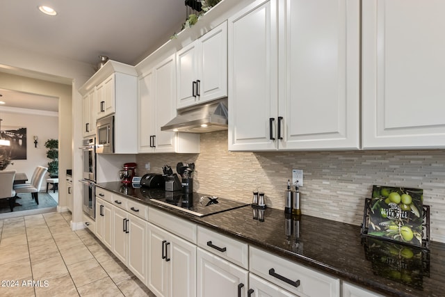 kitchen with dark stone counters, tasteful backsplash, light tile floors, double oven, and white cabinetry