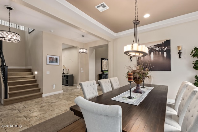 tiled dining space featuring an inviting chandelier and a tray ceiling