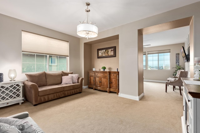 carpeted living room with a chandelier