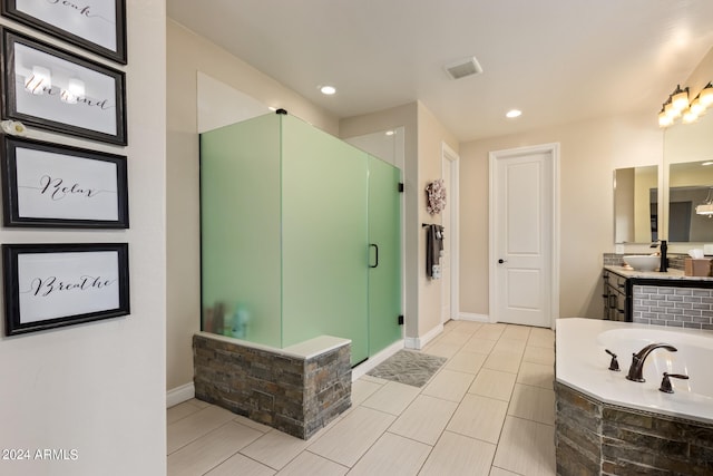 bathroom featuring tile floors, vanity, and independent shower and bath