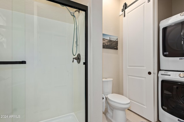 bathroom featuring stacked washer / drying machine and toilet