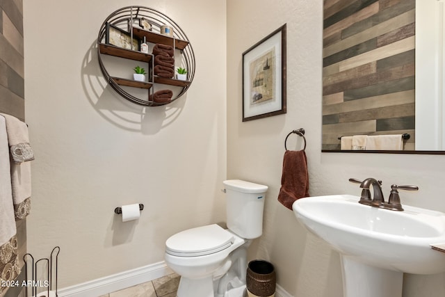 bathroom featuring toilet, tile floors, and sink