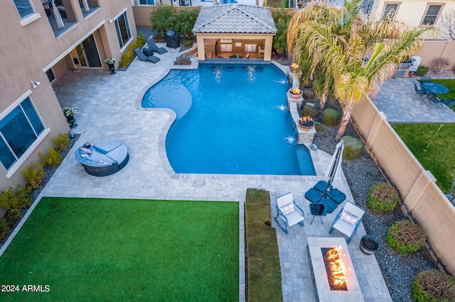 view of pool featuring an outdoor fire pit, a patio area, pool water feature, and a lawn