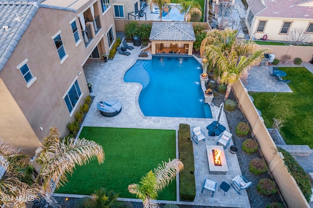 view of swimming pool featuring a lawn, an outdoor fire pit, a patio, and a gazebo