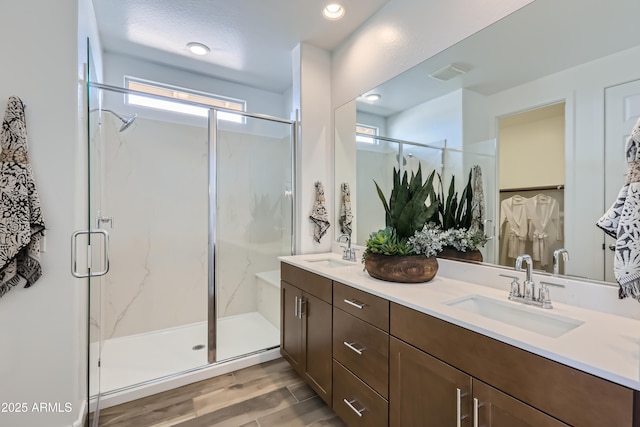 3129 S 155th Ln, Goodyear, AZ 85338 - full bathroom with double vanity, wood finished floors, a marble finish shower, and recessed lighting