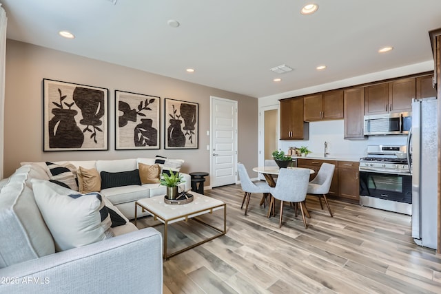3129 S 155th Ln, Goodyear, AZ 85338 - living room featuring light wood-type flooring and recessed lighting