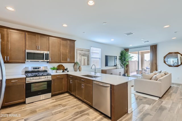 3129 S 155th Ln, Goodyear, AZ 85338 - kitchen with appliances with stainless steel finishes, a peninsula, light countertops, light wood-type flooring, and recessed lighting