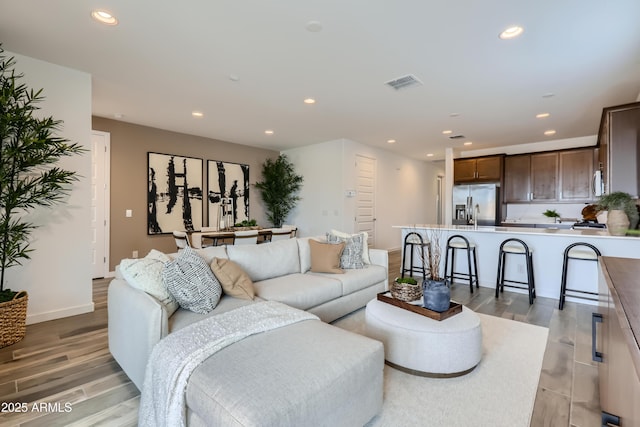3129 S 155th Ln, Goodyear, AZ 85338 - living room featuring light wood-style flooring and recessed lighting