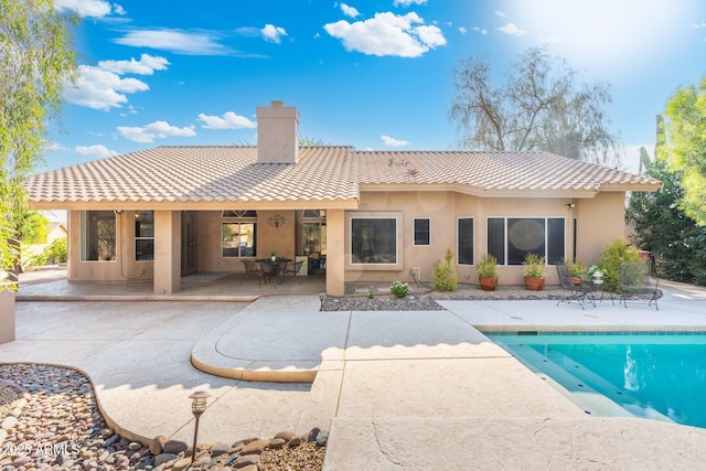 19275 N 88th Way, Scottsdale, AZ 85255 - back of house featuring a chimney, a patio, a tile roof, an outdoor pool, and stucco siding