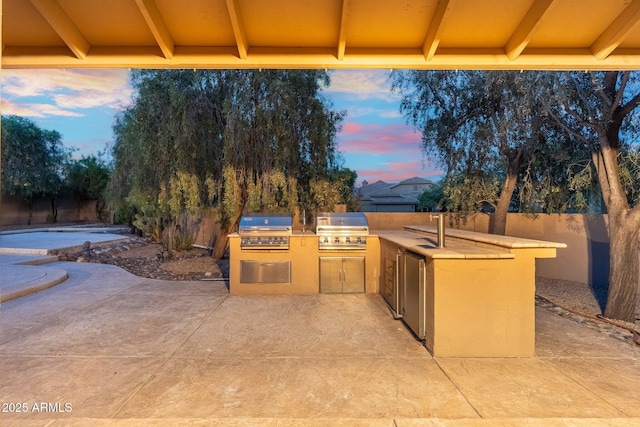 19275 N 88th Way, Scottsdale, AZ 85255 - patio terrace at dusk with area for grilling, a patio, and a fenced backyard