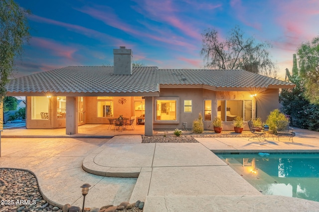 19275 N 88th Way, Scottsdale, AZ 85255 - rear view of house with a tiled roof, a chimney, a patio area, and an outdoor pool