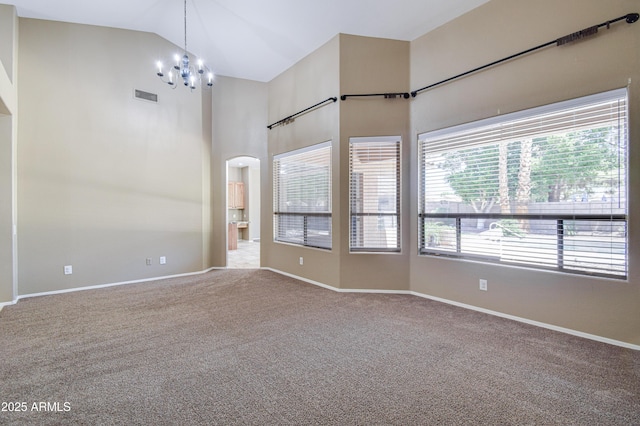 1470 W Bartlett Way, Chandler, AZ 85248 - empty room featuring a chandelier, carpet flooring, baseboards, high vaulted ceiling, and arched walkways