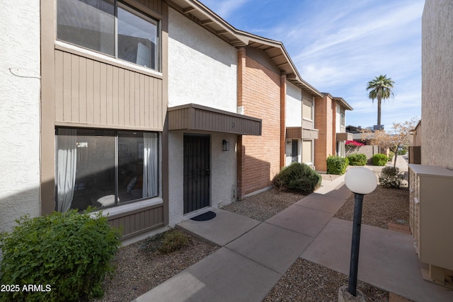 entrance to property with fence and stucco siding