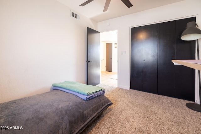 bedroom featuring a closet, carpet flooring, visible vents, and a ceiling fan