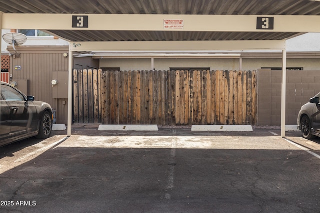 garage featuring covered parking and fence