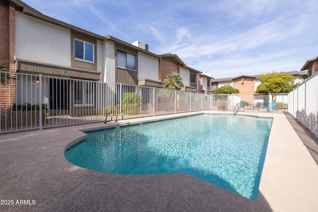 community pool with fence and a patio