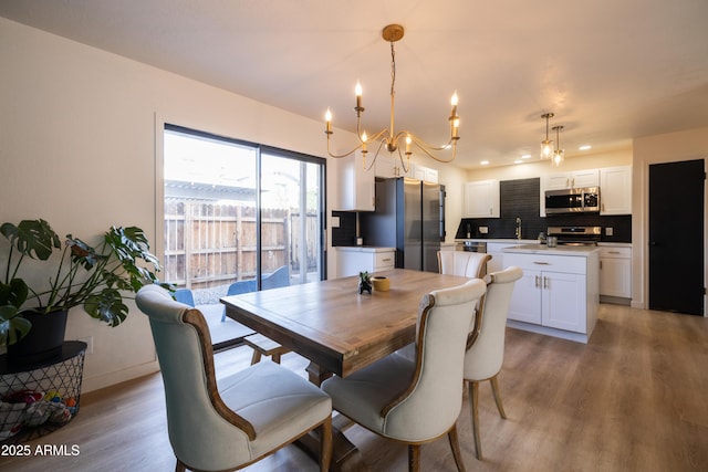 dining room featuring light wood-style flooring and baseboards