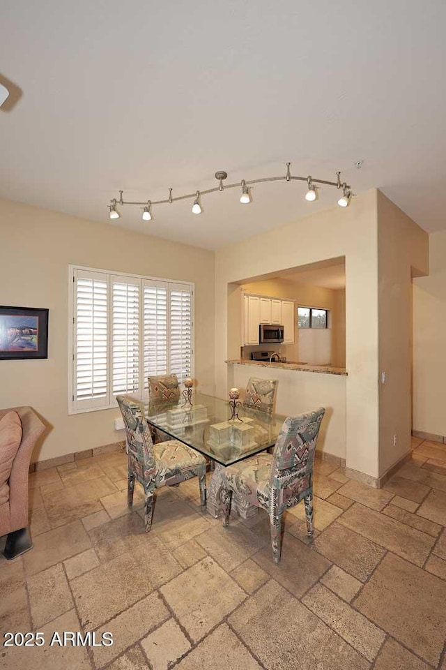 dining area featuring stone tile floors and baseboards