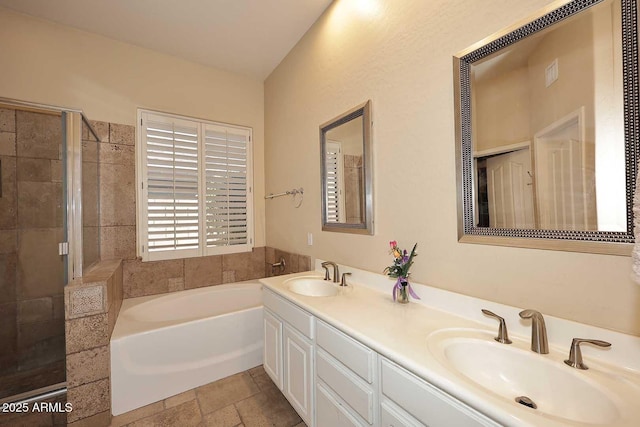 bathroom featuring double vanity, a bath, a stall shower, and a sink