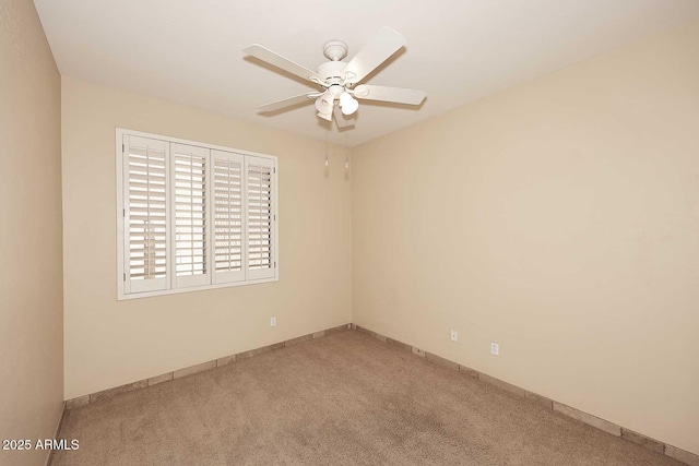 empty room with ceiling fan, baseboards, and carpet