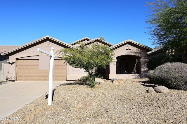 view of front of home featuring stucco siding, driveway, a tile roof, and a garage