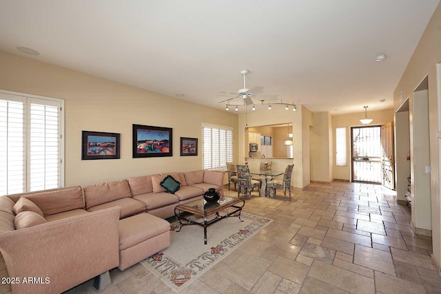 living room with stone tile flooring and ceiling fan