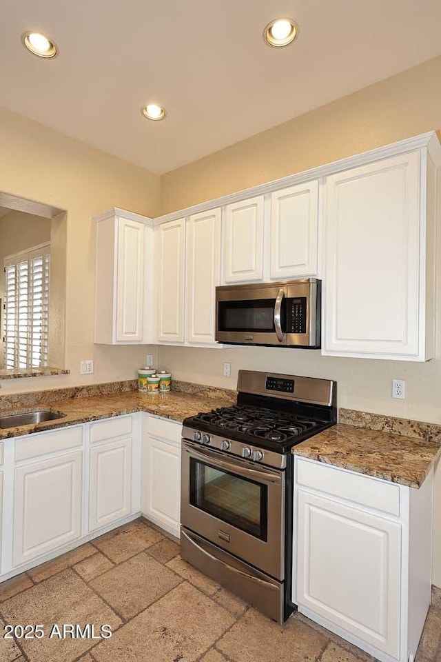 kitchen featuring a sink, stainless steel appliances, recessed lighting, and white cabinetry