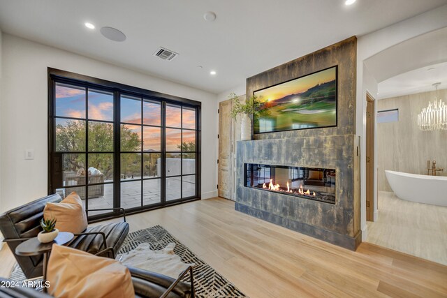 living room featuring a tile fireplace and light hardwood / wood-style floors