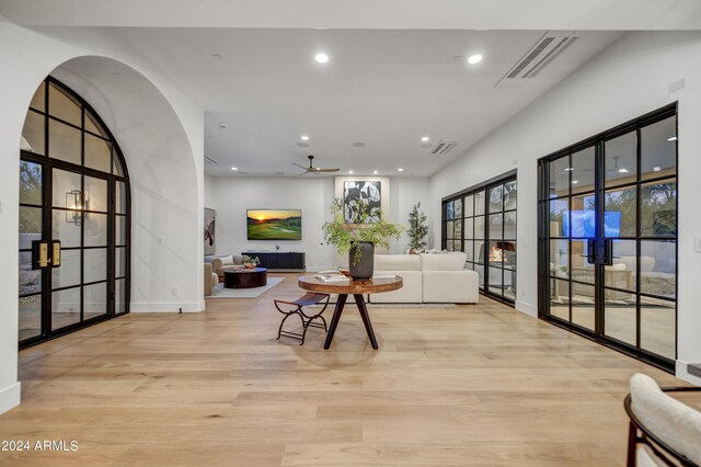 living room with a healthy amount of sunlight, ceiling fan, and light wood-type flooring