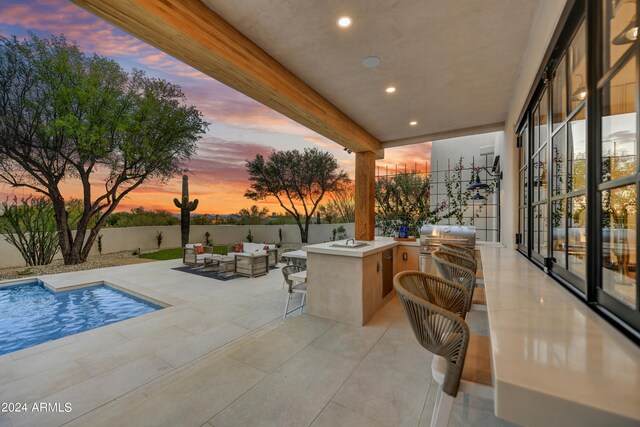 patio terrace at dusk with a grill, a fenced in pool, an outdoor hangout area, and area for grilling