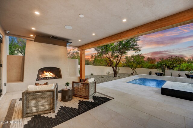 patio terrace at dusk with an outdoor fireplace