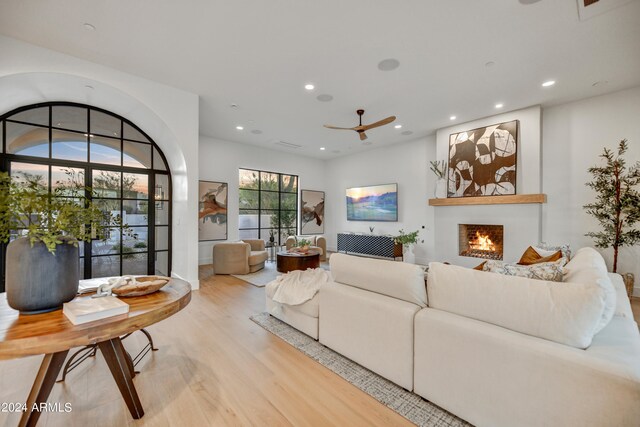 living room with ceiling fan and light hardwood / wood-style flooring