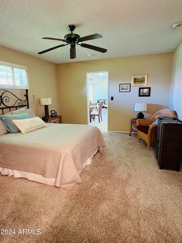 carpeted bedroom featuring a textured ceiling and ceiling fan