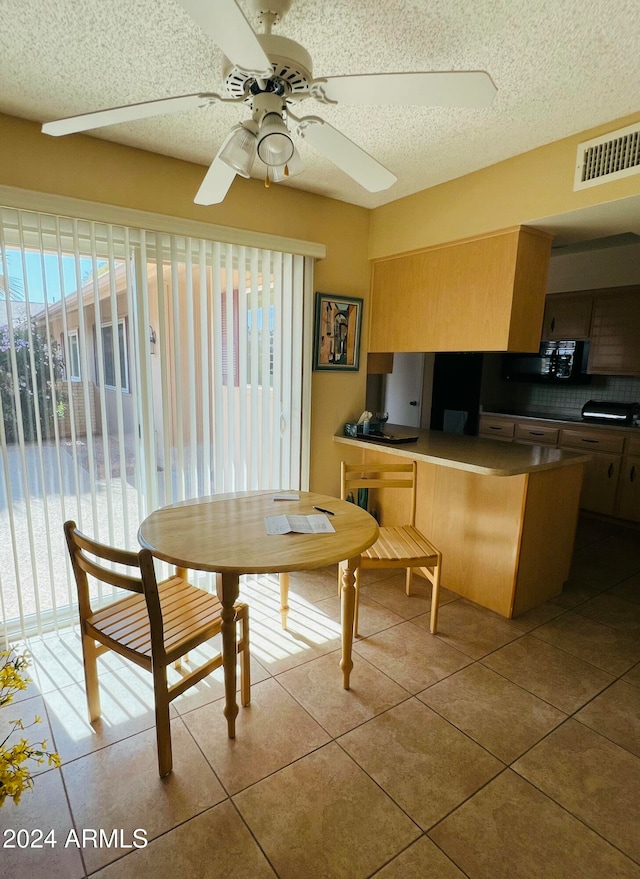 dining space with light tile patterned floors, a textured ceiling, and ceiling fan