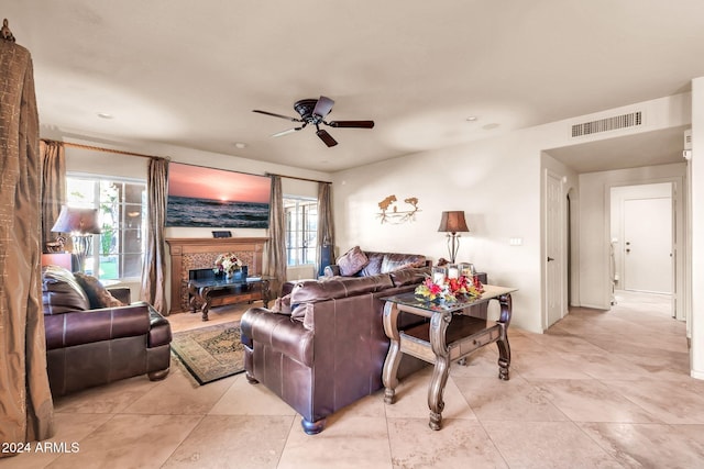 living room with ceiling fan and a fireplace