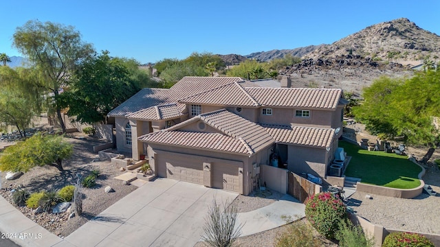 view of front of house featuring a mountain view, a front yard, and a garage