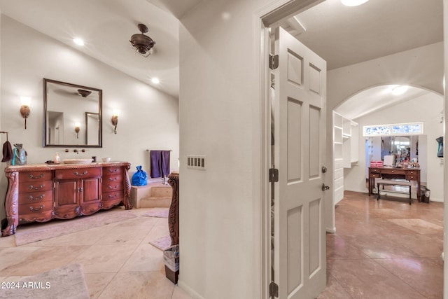 hall featuring vaulted ceiling and light tile patterned floors