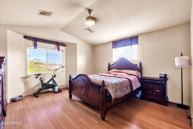 bedroom featuring wood-type flooring, vaulted ceiling, and ceiling fan