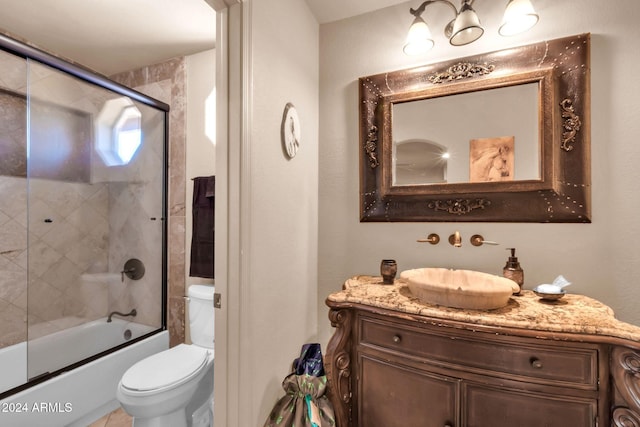 full bathroom featuring vanity, shower / bath combination with glass door, and toilet