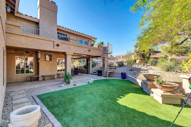 view of yard with a patio, a balcony, and ceiling fan