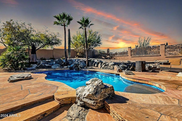 pool at dusk with a patio area