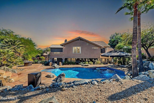 pool at dusk with a patio area