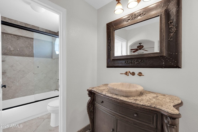 full bathroom featuring shower / bath combination with glass door, vanity, ceiling fan, toilet, and tile patterned floors