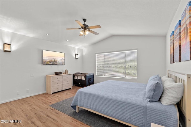 bedroom with ceiling fan, lofted ceiling, and light wood-type flooring