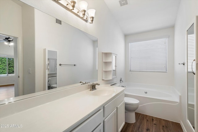 bathroom featuring toilet, lofted ceiling, ceiling fan, wood-type flooring, and a bathtub