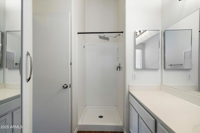 bathroom featuring a shower and vanity