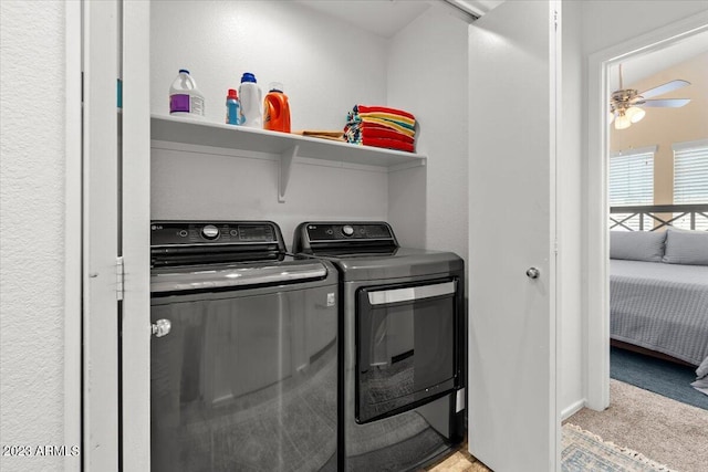 clothes washing area featuring ceiling fan, light colored carpet, and washer and dryer